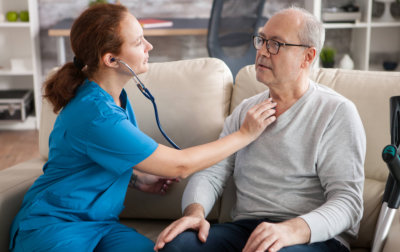 an elderly man and his family talking to a medical consultant